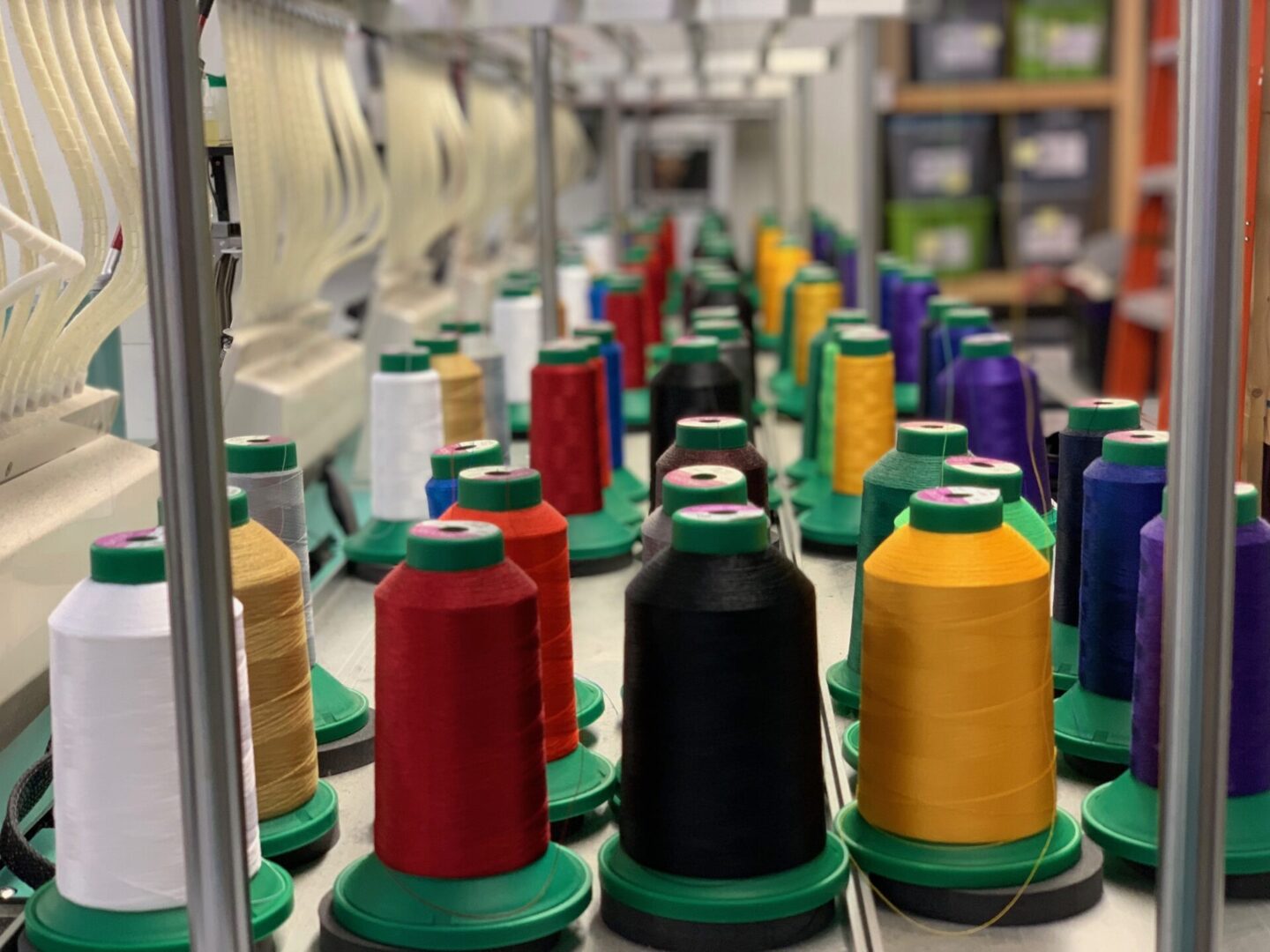 A row of spools of thread on a machine.